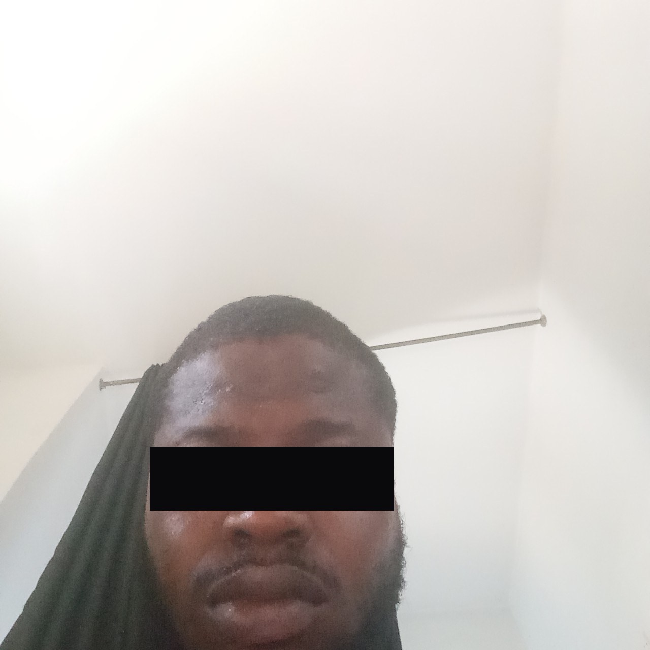 The silent-capture frame revealing the real person behind a stolen female escort profile — a man, eyes redacted